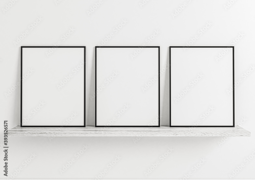 Three vertical black frame mockups. Black frame posters on clean white wall and white wooden shelf.
Three vertical black frame mockups. Black frame posters on clean white wall and white wooden shelf.