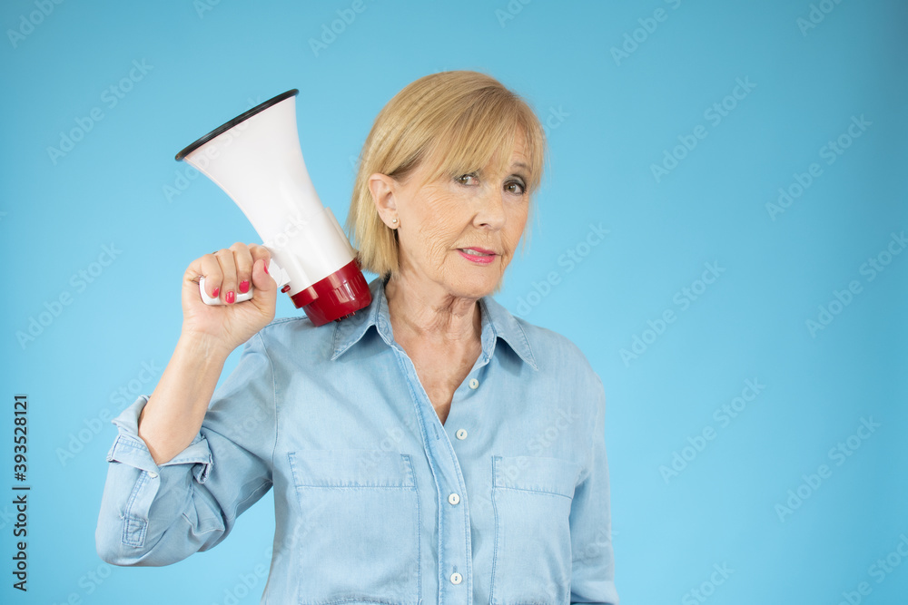 Cheerful senior woman holding a megaphone, communication and advertising concept Cheerful senior woman holding a megaphone, communication and advertising concept