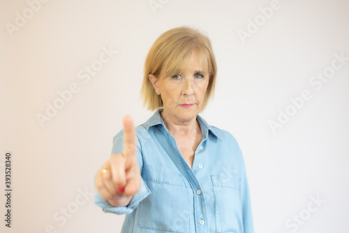 Old lady showing finger up gesture, smiling on white background