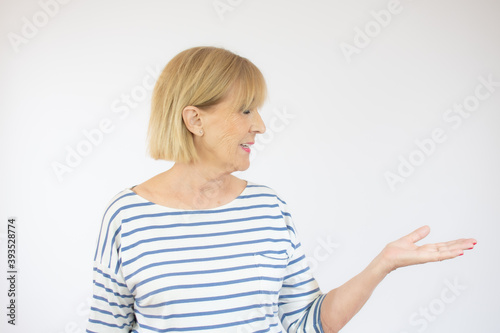 Smile senior woman holding something on open palm
