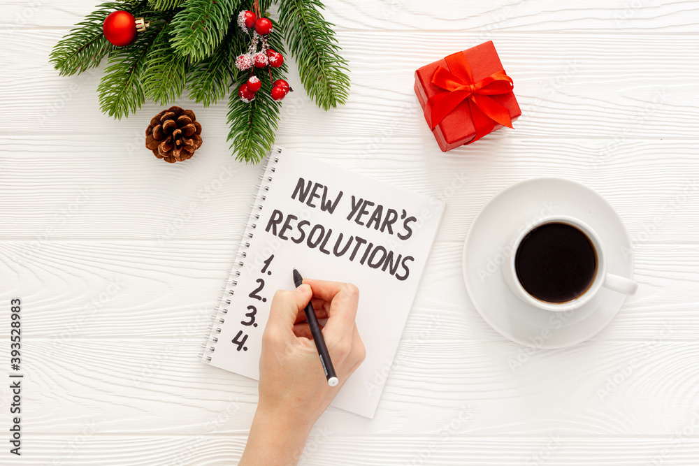 New Year's resolutions with Christmas decorations on yellow flat lay New Year's resolutions with Christmas decorations on yellow flat lay