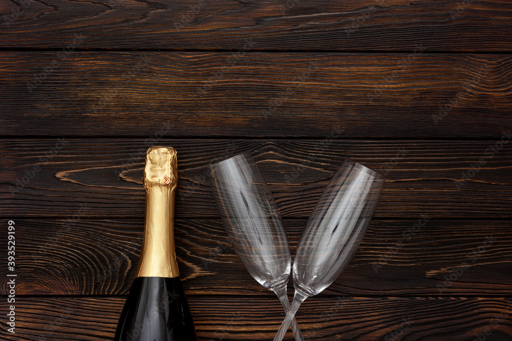 Champagne as New Year symbol on dark wooden background top view