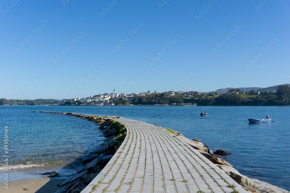rocky harbor jetty and the Eo River with the city of Castropol in the background