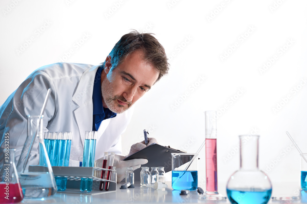 Scientist writing in a notebook on a laboratory table isolated Scientist writing in a notebook on a laboratory table isolated
