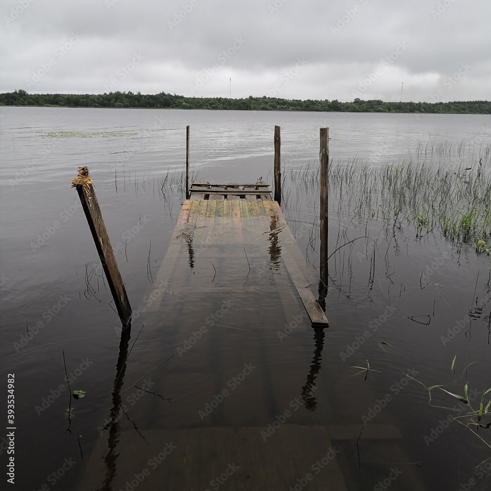 Naklejka premium flooded half bridge by the lake