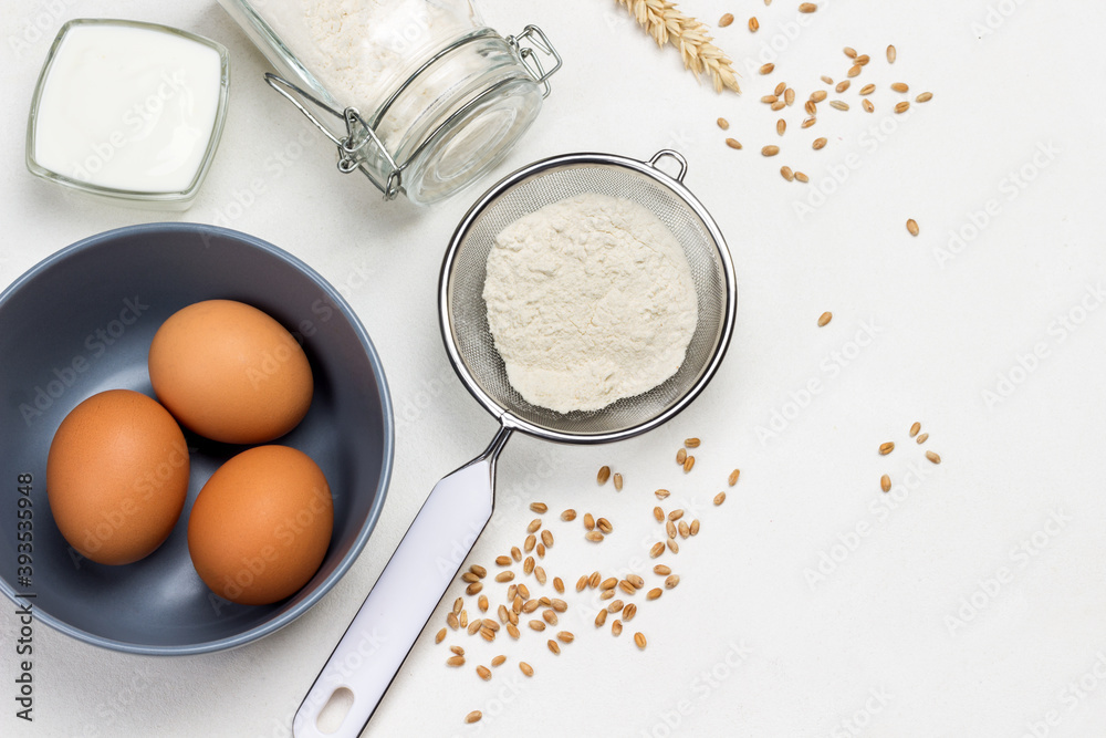 Flour in wooden spoon, sieve and glass jar. Flour in wooden spoon, sieve and glass jar.