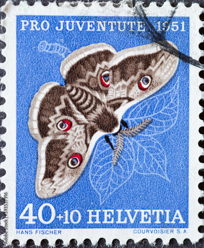 Switzerland - Circa 1951 : a postage stamp printed in the swiss showing a Viennese night peacock butterfly (Saturnia pyri) on a pear leaf