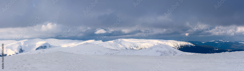 A panorama of a snow-covered mountain range. Panorama from multiple shots.
