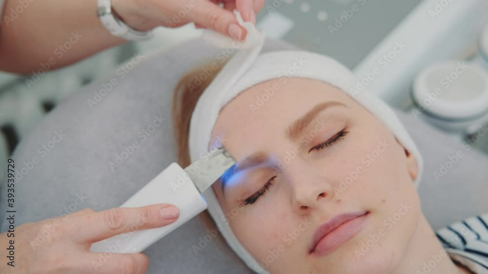 Close-up shot of cosmetician making cavitation facial peeling. Woman resting after hard working week. Close-up shot of cosmetician making cavitation facial peeling. Woman resting after hard working week.