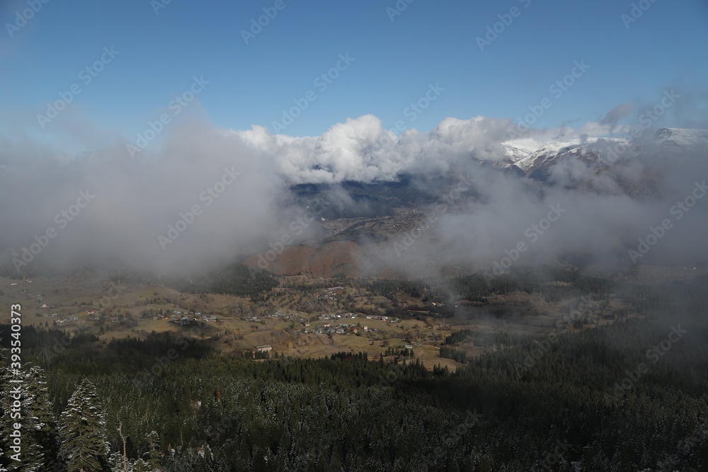 Snowy mountains covered in clouds beautified by the sky