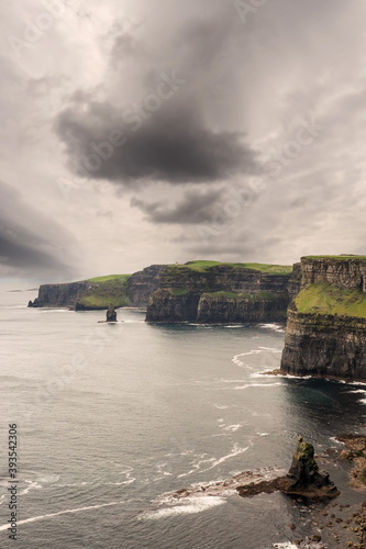 View on Cliff of Moher, county Clare, Ireland. Popular tourist attraction with epic view. Cloudy sky. Nobody.