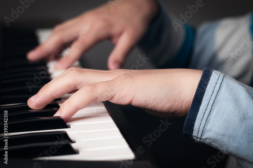 Manos de niño tocando el piano