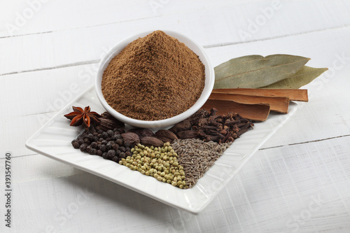 Fototapeta Naklejka Na Ścianę i Meble -  Ingredients of Indian garam masala in a white platter