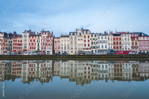 views of nive river in bayonne with traditional houses at background