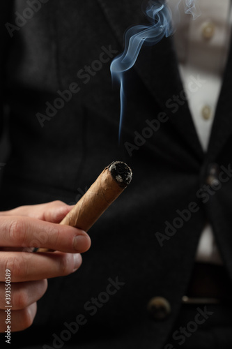 The Man'S Hand Holds A Smoking Cigar. Shallow depth of field
