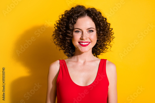 Close-up portrait of her she nice-looking attractive lovely charming grogeous glamorous cheerful wavy-haired girl wearing tanktop isolated bright vivid shine vibrant yellow color background photo