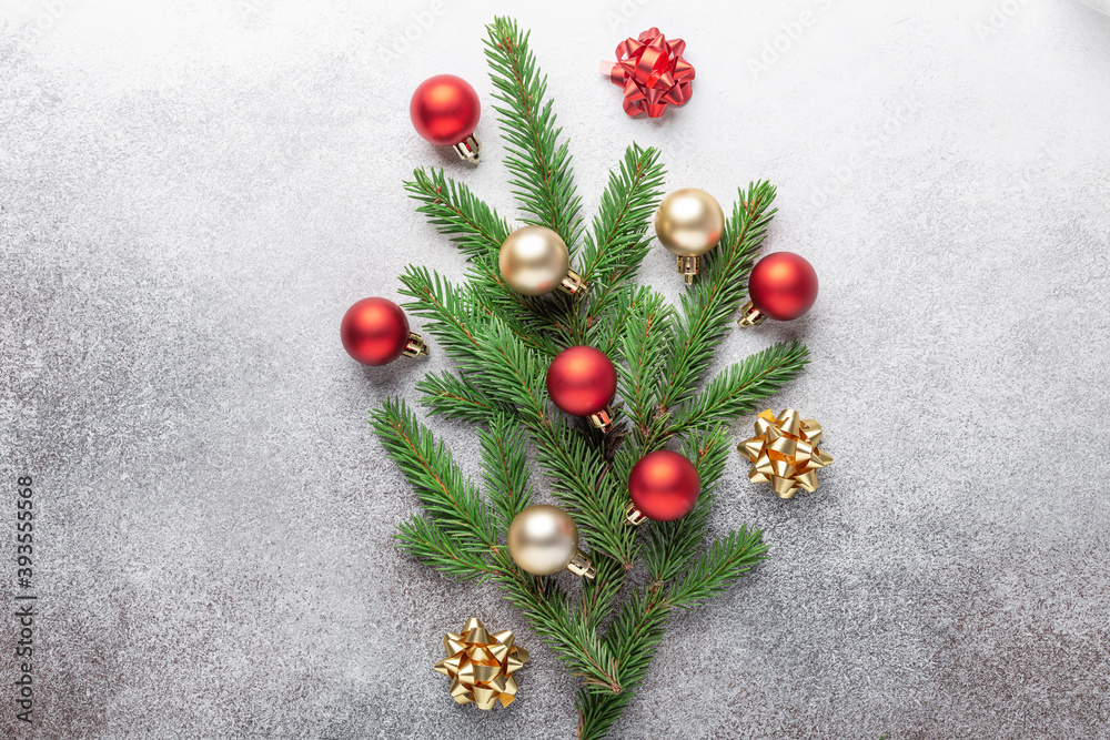 Minimal christmas composition. Bouquet of fir tree branches with red and gold christmas balls on stone background Minimal christmas composition. Bouquet of fir tree branches with red and gold christmas balls on stone background