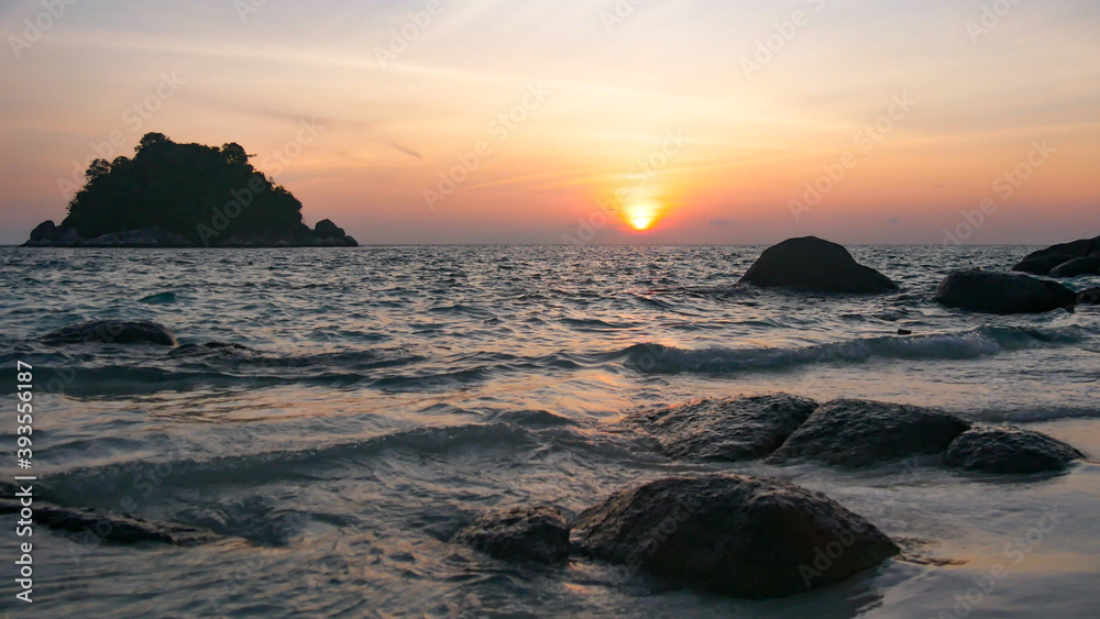 Golden Sunset into the sea with the silhouette of an island Golden Sunset into the sea with the silhouette of an island