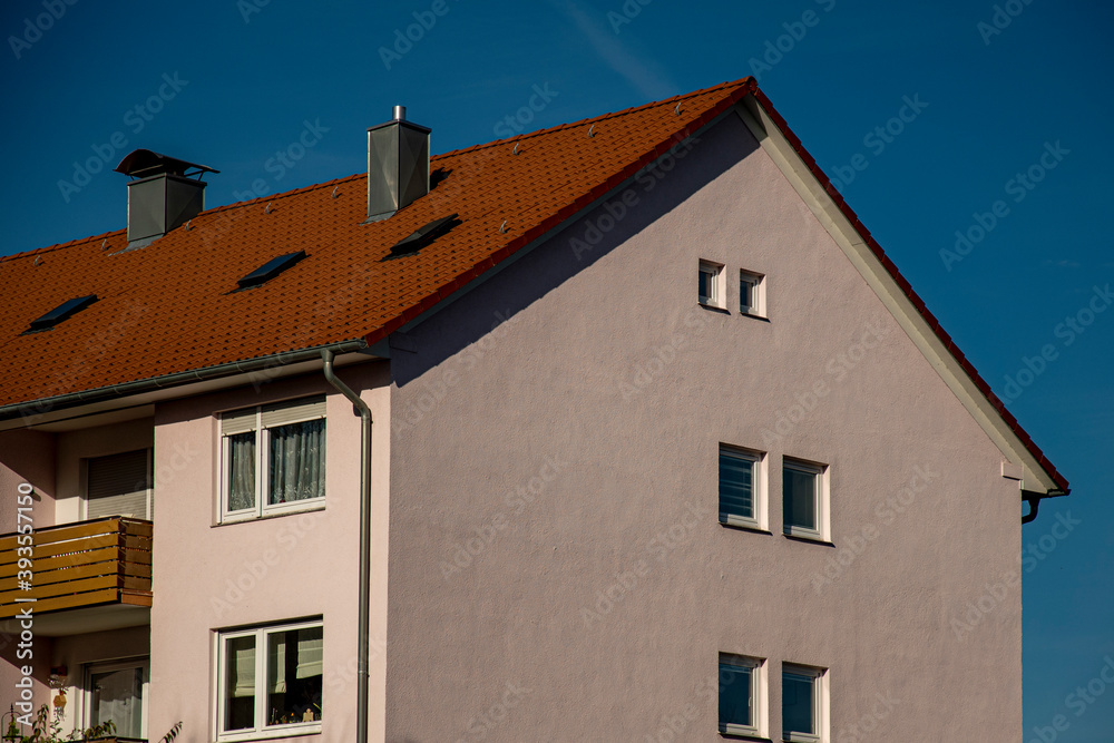 Apartment house with blue sky and red roof