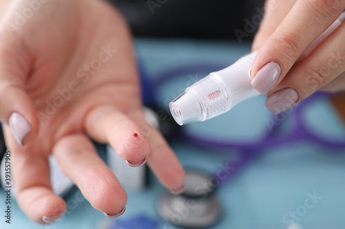 Blood sampling from a finger with lancet. Blood test concept