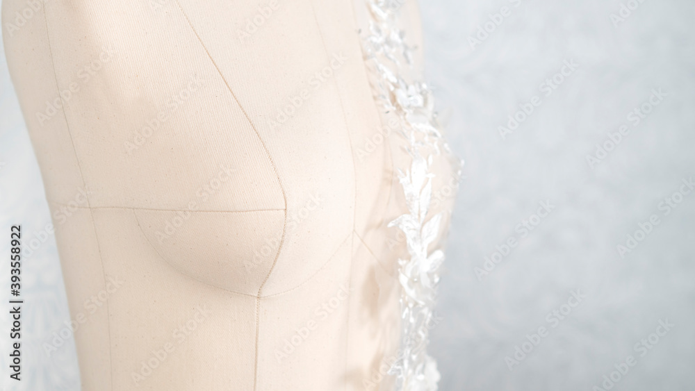Obraz premium Woman sewing mannequin with white delicate lace fabric on it.
