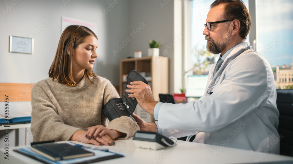 Doctor's Office: Physician Measures Blood Pressure of a Female Patient, Discussing Symptoms, Possible Prescription of Hypertension Drugs. Medical Health Care Specialist or Cardiologist Using Tonometer Doctor's Office: Physician Measures Blood Pressure of a Female Patient, Discussing Symptoms, Possible Prescription of Hypertension Drugs. Medical Health Care Specialist or Cardiologist Using Tonometer