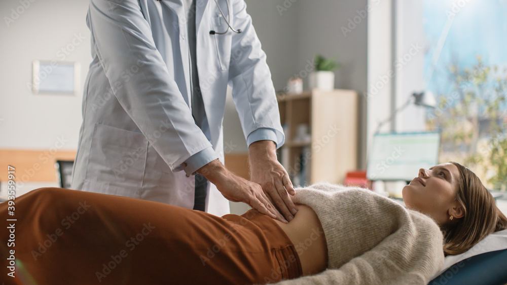 Doctor Consultation Office: Female Patient Lying on a Bed while Family Physician Checks Her Abdomen. Medical Health Care Specialist Localizes Stomach Pain, Identifying Disease, Prescribing Treatment Doctor Consultation Office: Female Patient Lying on a Bed while Family Physician Checks Her Abdomen. Medical Health Care Specialist Localizes Stomach Pain, Identifying Disease, Prescribing Treatment