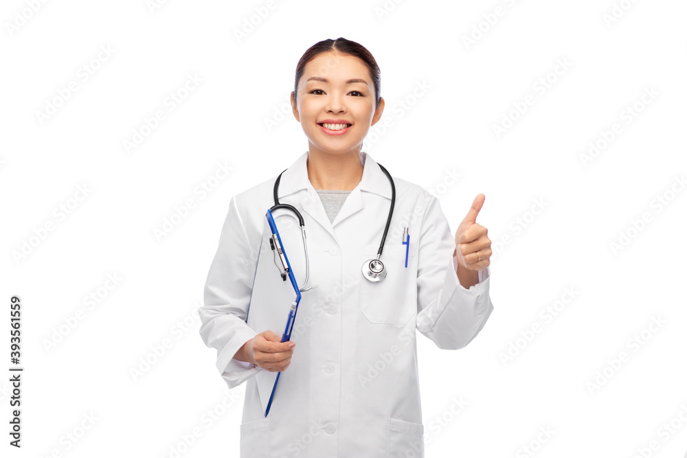 medicine, profession and healthcare concept - happy smiling asian female doctor in white coat with clipboard showing thumbs up