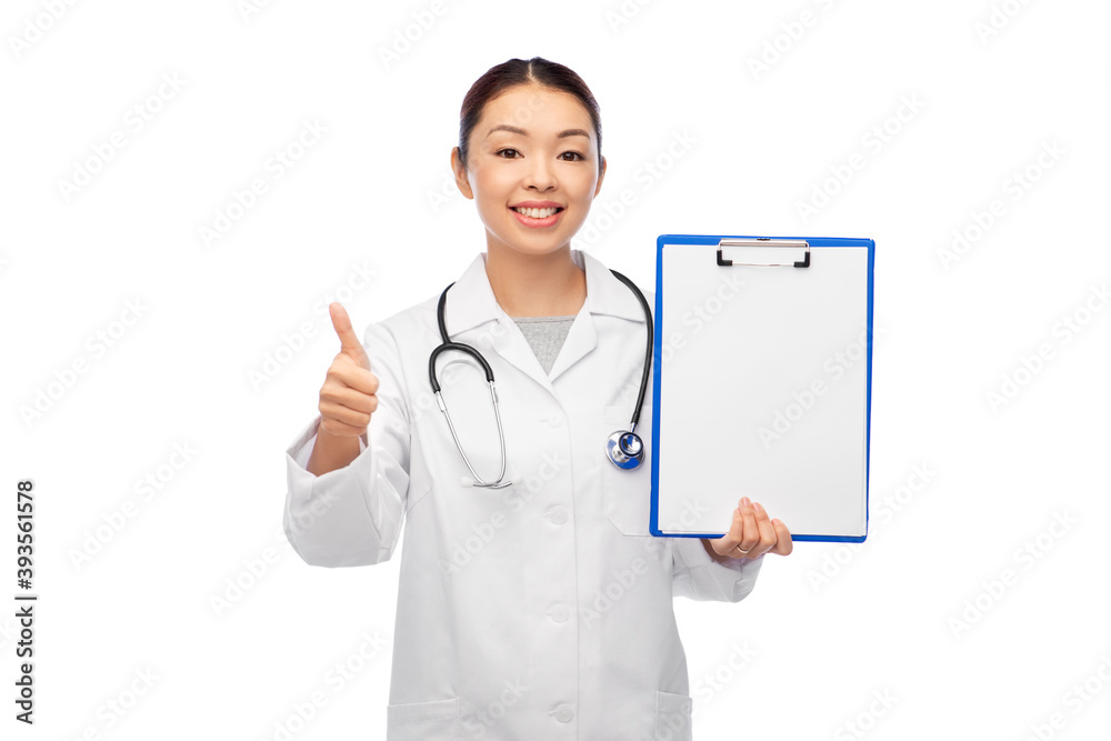 medicine, profession and healthcare concept - happy smiling asian female doctor in white coat with clipboard showing thumbs up