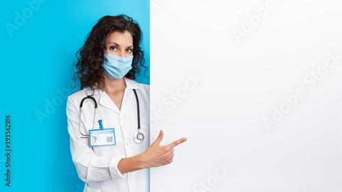 Doctor in face mask on bright color background make gesture hand. Girl wearing protection face mask covid-19. Banner medical staff preventive gear about coronavirus. Woman in medical mask covid-2019