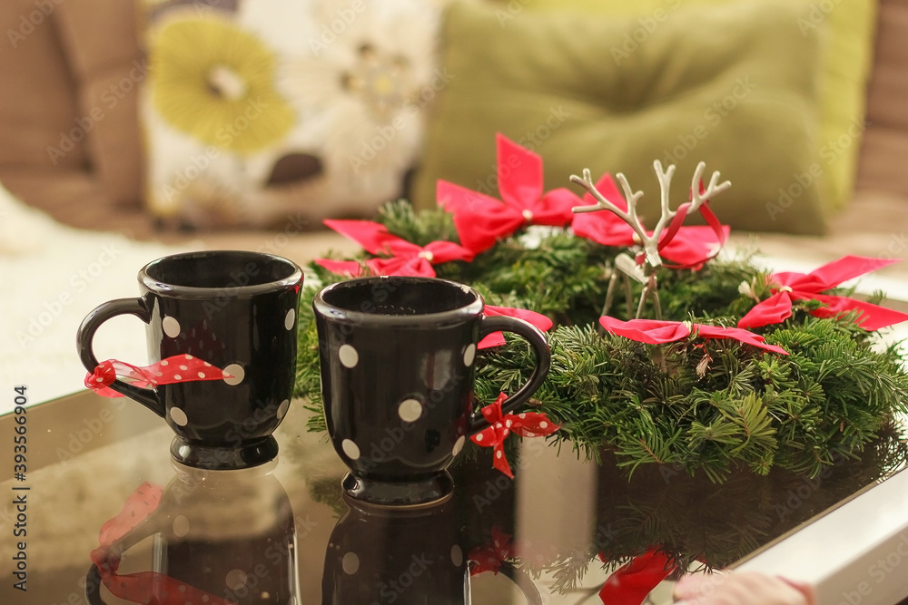 Two cups with a hot tea. concept of family winter holidays. 2 cups of coffee with branch of christmas tree wreath Two cups with a hot tea. concept of family winter holidays. 2 cups of coffee with branch of christmas tree wreath