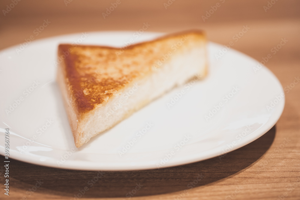 Triangle of garlic bread on white dish