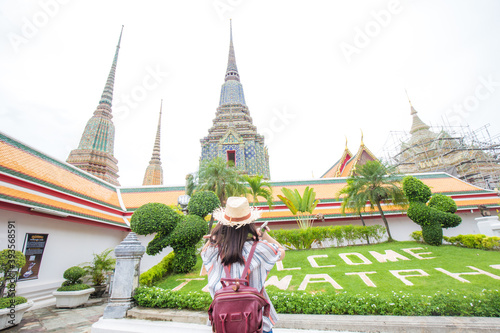 Pretty young asian backpack woman walking in the famous temple in Bangkok.
