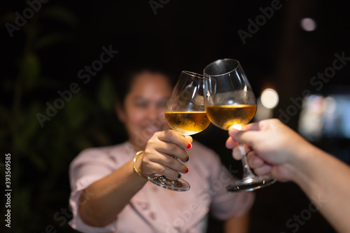Shot in high iso with low light couple toasting wineglasses on vacation.