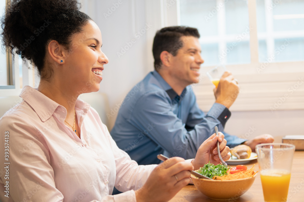 Latin black business woman talking causally with co-workers in cafeteria area. Candid, connection, break, relaxation, chatting concept.. Latin black business woman talking causally with co-workers in cafeteria area. Candid, connection, break, relaxation, chatting concept..