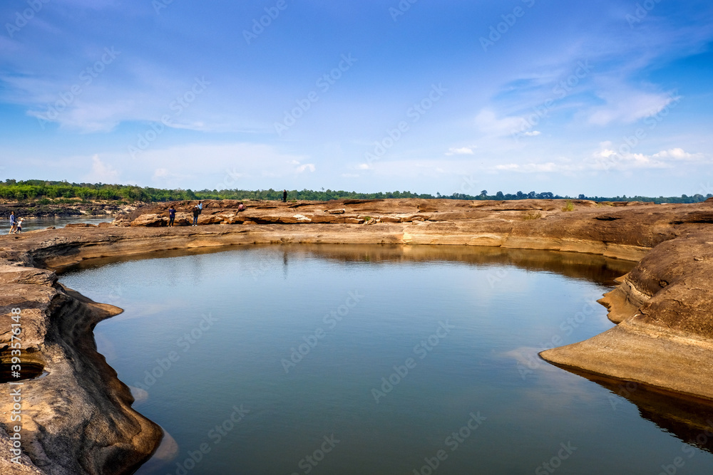 On the Mekong River bordering Thailand and Laos, the water is dry until it forms a tall rocky pit where people can see