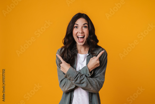 Excited beautiful girl pointing fingers at opposite sides