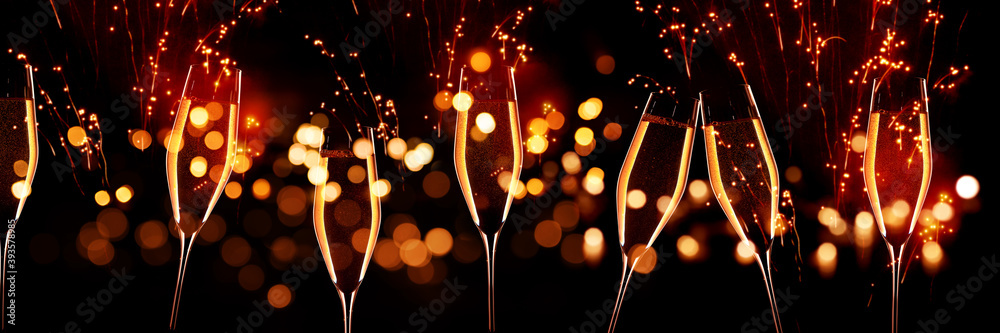 Celebrations with champagne in front of red glittering fireworks sky and golden bokeh. Horizontal background for silvester and wedding. Special occasion concept. - obrazy, fototapety, plakaty 