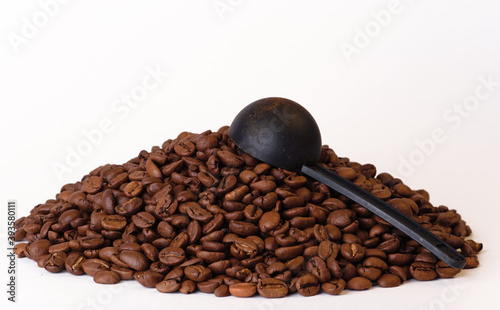 Black coffee beans arabica rabusta with black plastic spoon photo