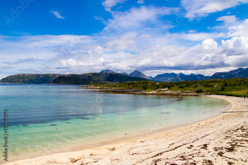 Scenic view of a white beach surrounded by mountains and turquoise ocean in Northern Norway