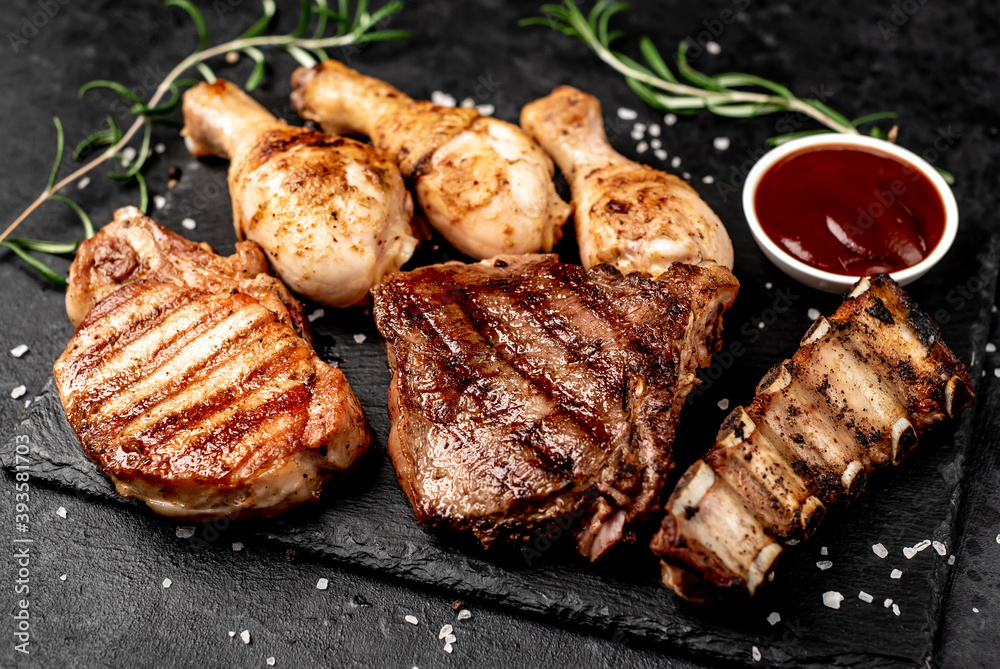 Various types of grilled meat, beef, pork, chicken on stone background	
