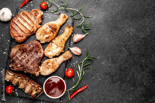 Various types of grilled meat, beef, pork, chicken on stone background	with copy space	