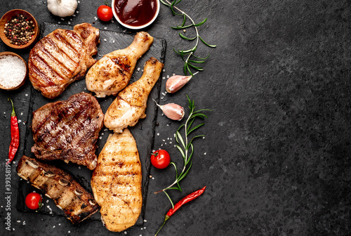 Various types of grilled meat, beef, pork, chicken on stone background	with copy space	