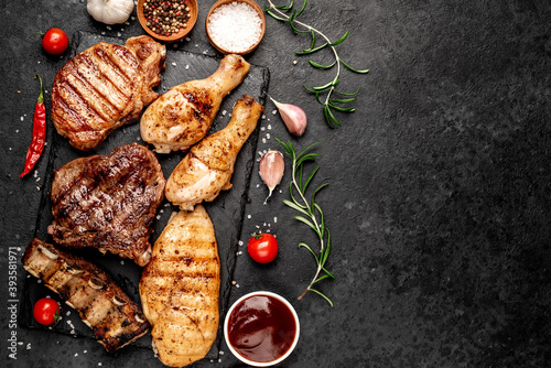 Various types of grilled meat, beef, pork, chicken on stone background with copy space 