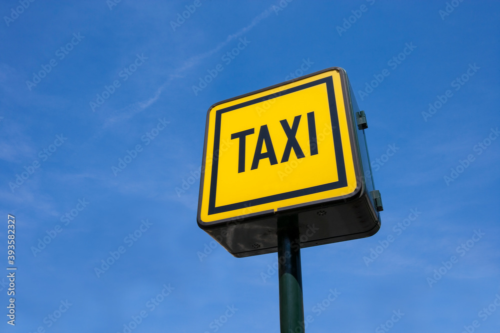 Low angle view of taxi sign against blue sky Low angle view of taxi sign against blue sky