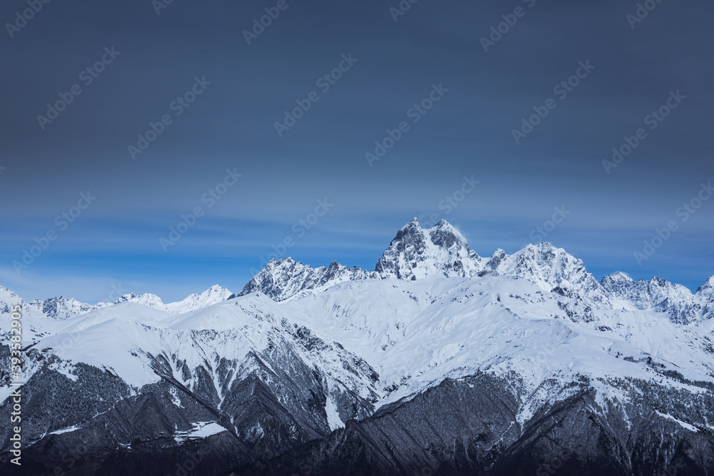 Panoramic view on high snowy mountains in winter at sunny day. Caucasus Mountains, Mount Ushba. Svaneti region of Georgia