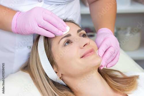 cosmetology. young woman with receiving facial cleansing procedure in beauty salon.