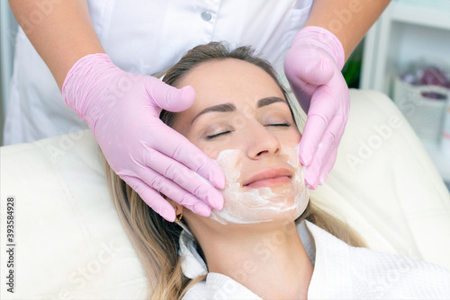 cosmetology. young woman with receiving facial cleansing procedure in beauty salon.