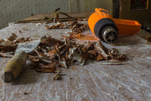 Restoration of an old door. Removing old paint coats with a heat gun and a spatula. Gnarled pieces of old brown paint. Furrows of old white putty.