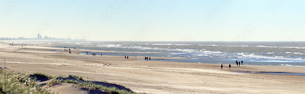 Social distance on the beach: people having a walk on a windy day during the Covid lock-down in autumn 2020; Noordwijk, the Netherlands